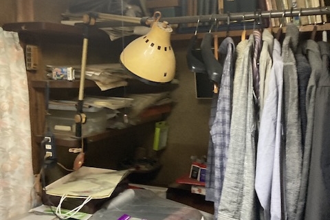 宇都宮市のリフォーム予定住宅で、収納棚に衣類や本が雑然と積まれている室内の様子