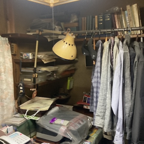 宇都宮市のリフォーム予定住宅で、収納棚に衣類や本が雑然と積まれている室内の様子