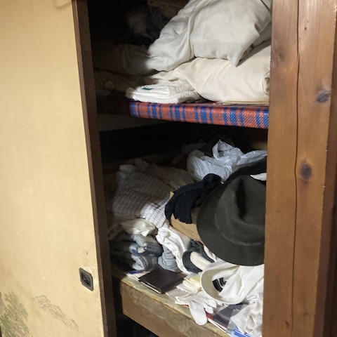 押し入れ内部に布団や衣類が詰め込まれたリフォーム前住宅の収納スペース