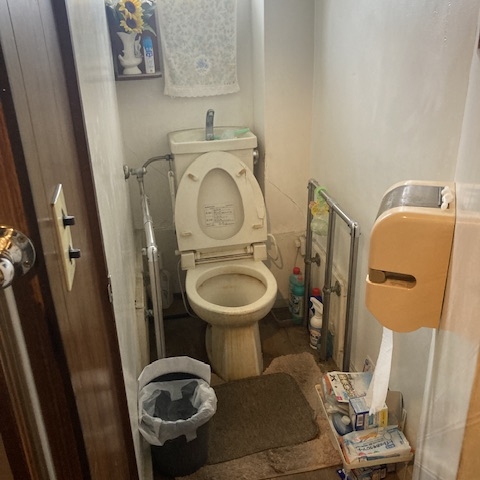 トイレ周辺に生活用品が散乱しているリフォーム前住宅の室内状況