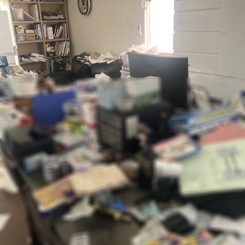 栃木県下野市の戸建て住宅LDKにて撮影した片付け前の様子。テーブルや床に書類や雑貨が散乱し、生活動線が確保しづらい状態。