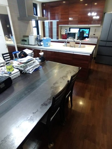 不用品片付け・清掃作業後に撮影したLDKの様子。テーブルやキッチンが整頓され、木目の床が見える清潔な空間に改善された。