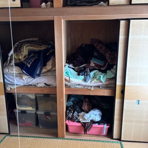 片付け前の和室押入れ内部｜布団や衣類が乱雑に収納された状態の収納スペース