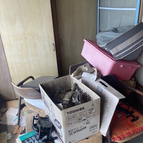 段ボールや日用品が積まれた和室の一角｜栃木県宇都宮市 解体前の不用品片付け現場