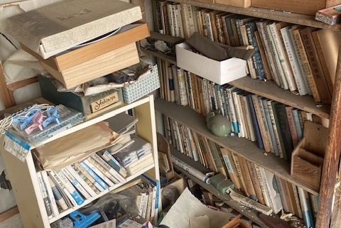 古本や収納用品が乱雑に残る本棚まわりの状態｜解体前の室内片付け対象エリア