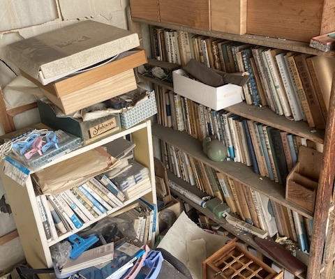 古本や収納用品が乱雑に残る本棚まわりの状態｜解体前の室内片付け対象エリア