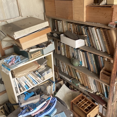 古本や収納用品が乱雑に残る本棚まわりの状態｜解体前の室内片付け対象エリア