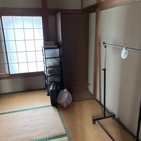 畳敷きの和室に設置された収納棚と洋服ラック、作業前の状態｜小山市の戸建て住宅での不用品仕分け作業前