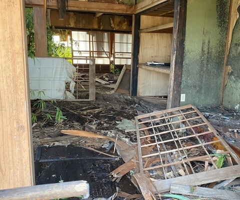 木造小屋1階に積まれた古い木材や家具の残置物｜栃木県高根沢町の空き家片付け前の様子