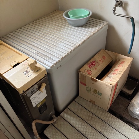 宇都宮市の市営住宅の浴室。備品や給湯器が残されたままで、床や壁の汚れが目立つ生前整理前の様子。