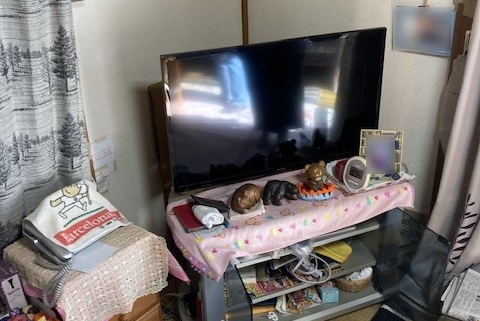 整理前の和室の様子。畳の上には生活用品や衣類が多く置かれている。