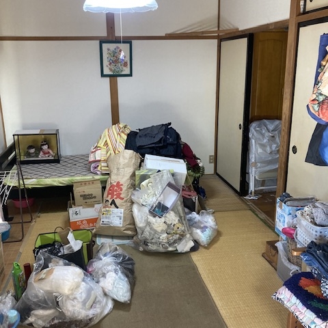 片付け前のリビング。テレビや棚などの家電・雑貨が混在。