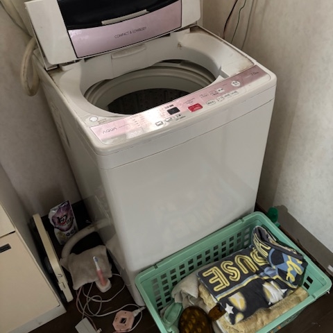 キッチンの片付け前。調理家電や調味料が多く、シンク周りに使用品が残っている。