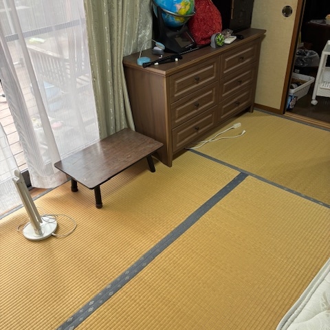 洗面所の片付け前。洗濯機周りに洗濯用品や雑貨が置かれている状態。